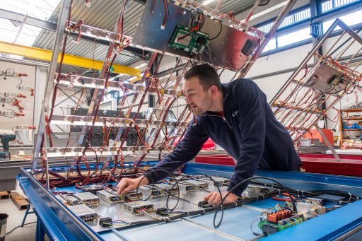 Medewerker productie werkt aan kablering van de behuizing voor een LED-scherm